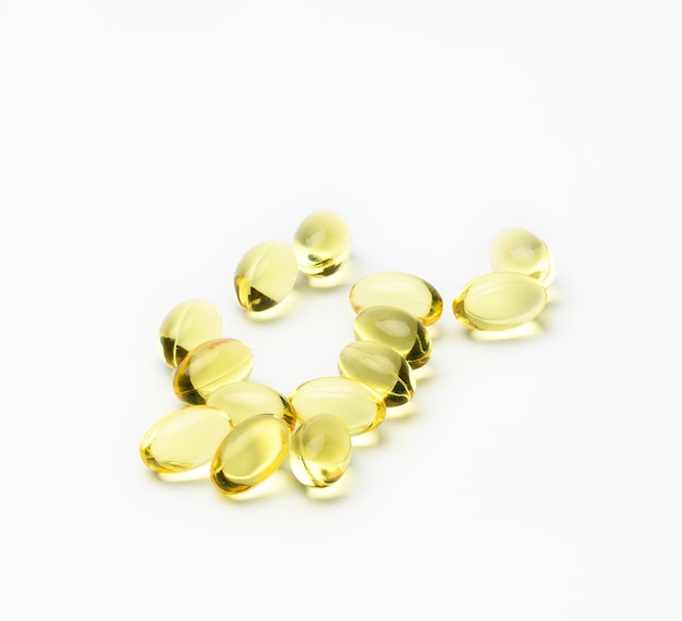 Fish oil capsules on white background, food supplement for health, close up