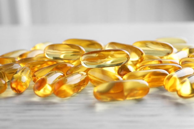 Fish oil capsules on white wooden table