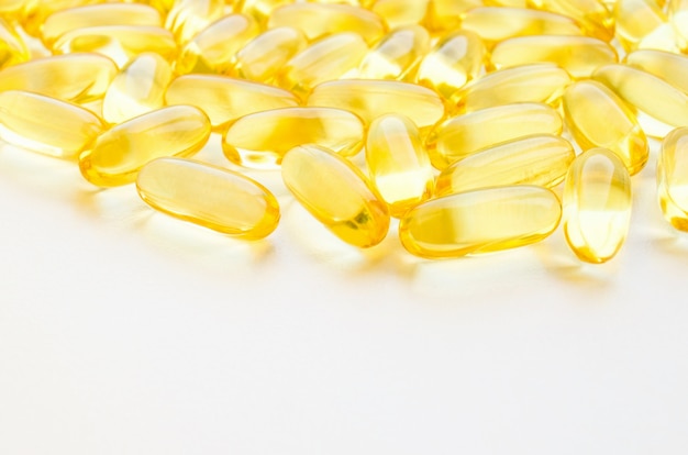 Fish oil fat capsules with omega 3 and vitamin D on white