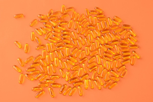 Fish oil, Omega-3. Healthy  product, medicines or vitamins in soft capsules on an orange background