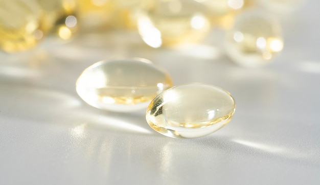 Fish Oil Omega 3 on white background vitamin D yellow supplement gel capsules macro shot