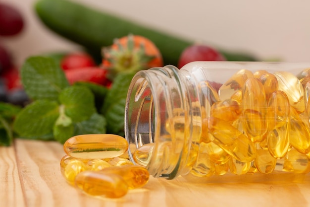 Fish oil omega 3 with vitamin Dcapsules in the glass bottle on wooden table with variety fruits