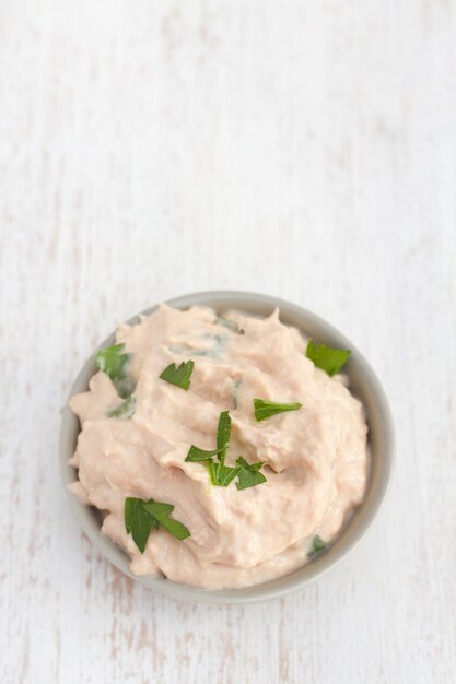 Fish pate with herbs on white surface