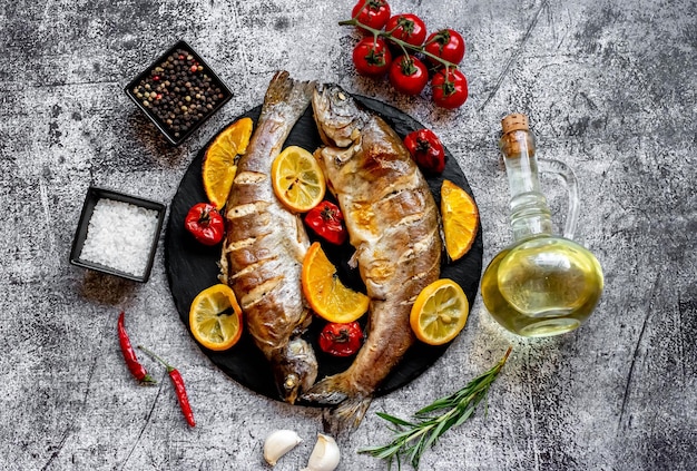 Foto pesce su un piatto con verdure e olio d'oliva