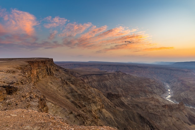 Fish River Canyon, scenic travel destination in Southern Namibia. Last sunlight on the mountain ridges. Wide angle view from above.