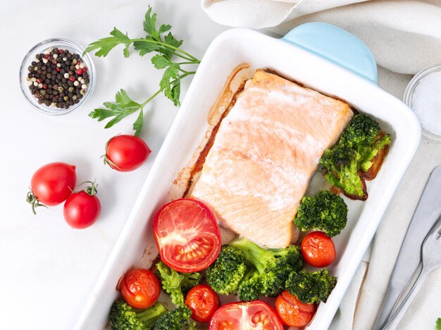 Photo fish salmon baked in oven with vegetables broccoli healthy diet food white marble backdrop