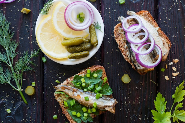 Fish sandwiches and a plate with lemon onions and gherkins