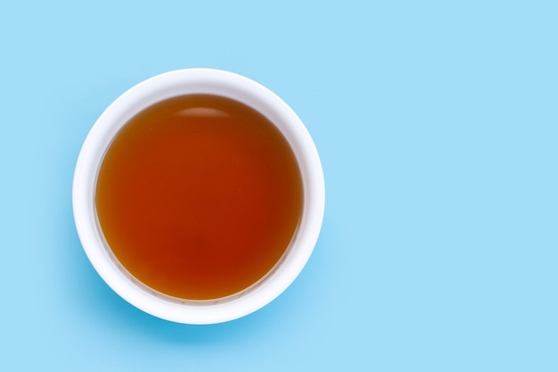 Fish sauce in white bowl on blue surface