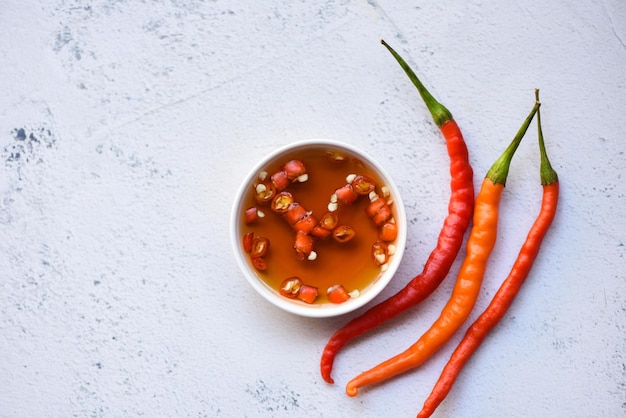 Fish sauce on white bowl and fresh chili on table fish sauce
obtained from fermentation fish or small aquatic animal fermented
foods