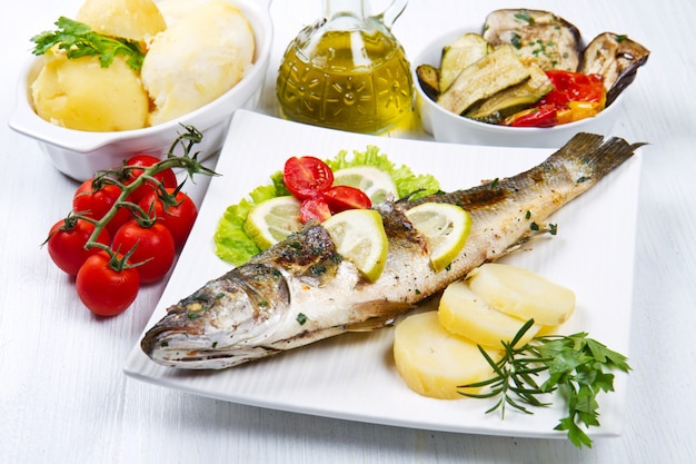 Fish, sea bass grilled with lemon ,salad and potatoes