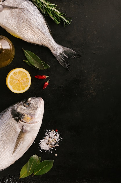 Fish and spices on dark table