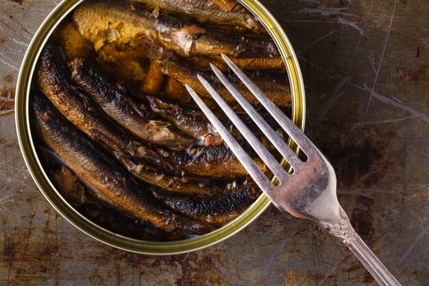 Foto spratti di pesce in scatola cibo in olio in una tincan