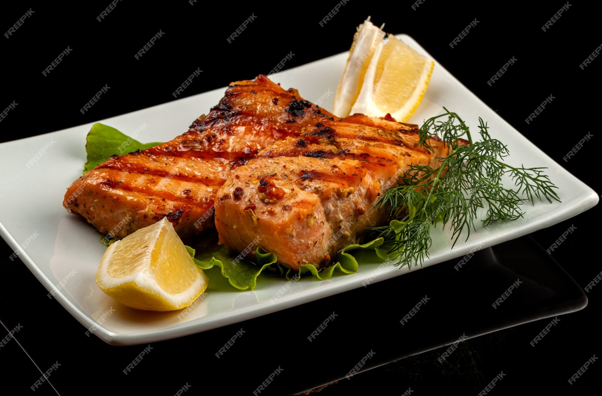 Premium Photo  Fish, trout, chum salmon, humpback, a piece baked, grilled,  with a slice of lemon and lettuce