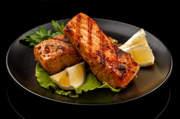 Fish, trout, chum salmon, humpback, a piece baked, grilled, with a slice of lemon and lettuce