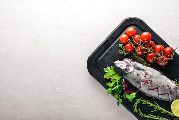 Fish trout with aromatic herbs and spices On Wooden background