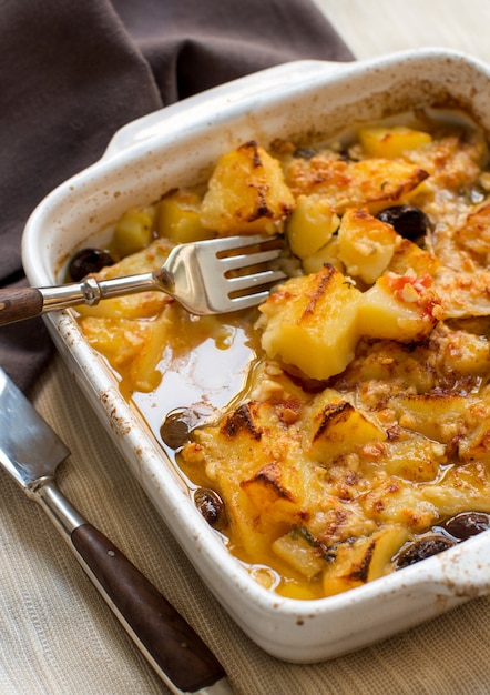 Photo fish with potatoes and olives cooked in the oven