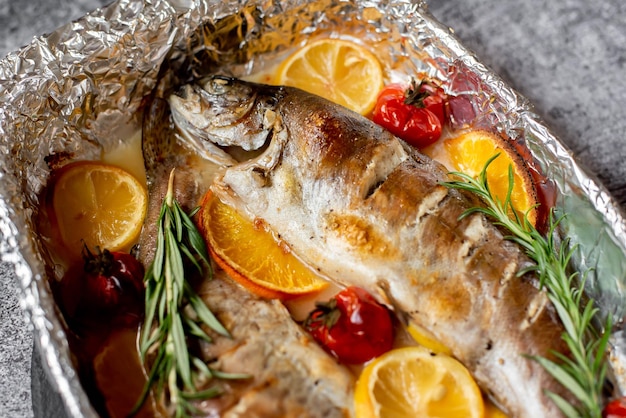 Photo a fish with rosemary on it and a bunch of vegetables on the side