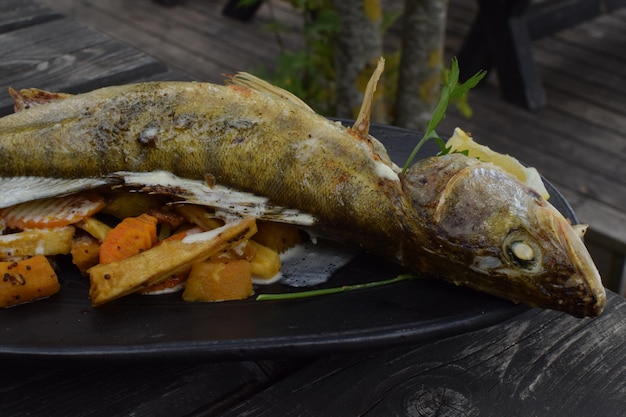 皿にポテトチップスを添えた魚