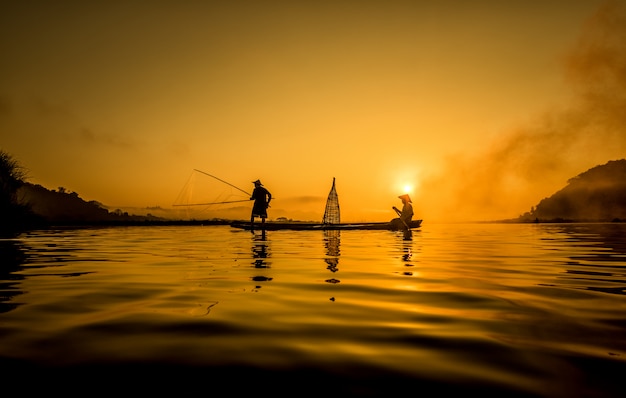 Pescatore in azione quando si pesca nel lago, thailandia