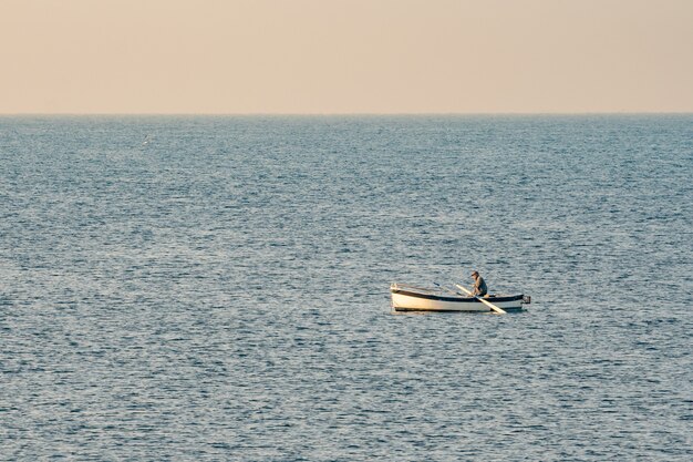 Fisherman in a boat fishing in the early morning. Mediterranean Sea. Italy.