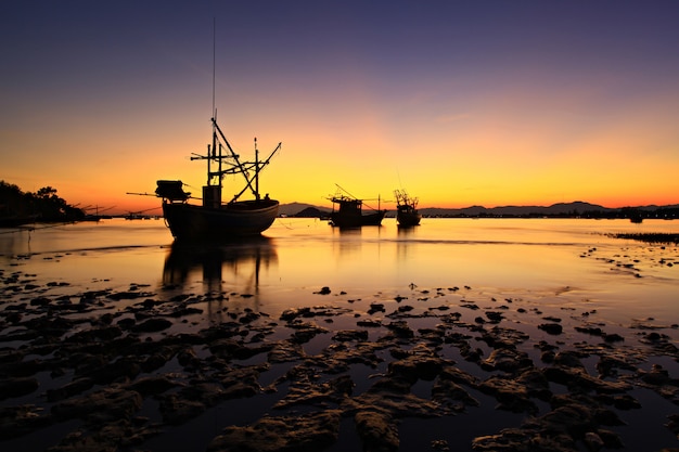 Fisherman boat is sailing back in the sunset 