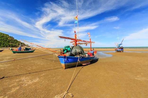 Fisherman boat on sand beach and blue sky