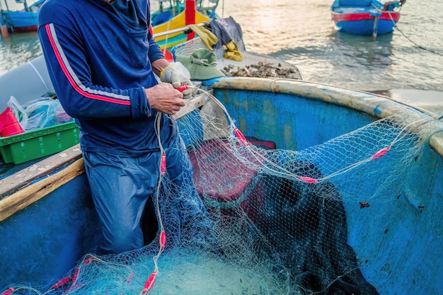 Foto pescatore che getta la sua rete all'alba o al tramonto i pescatori tradizionali preparano la rete da pesca