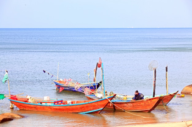 Fisherman cleaning his boat on the beach