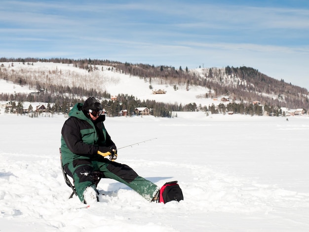 Fisherman enjoying a day on the frozen lake Granby, Colorado.