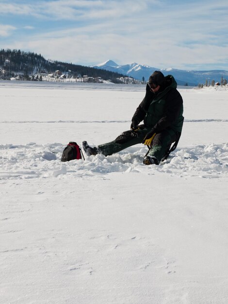 Fisherman enjoying a day on the frozen lake Granby, Colorado.