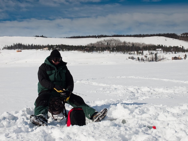 Fisherman enjoying a day on the frozen lake Granby, Colorado.