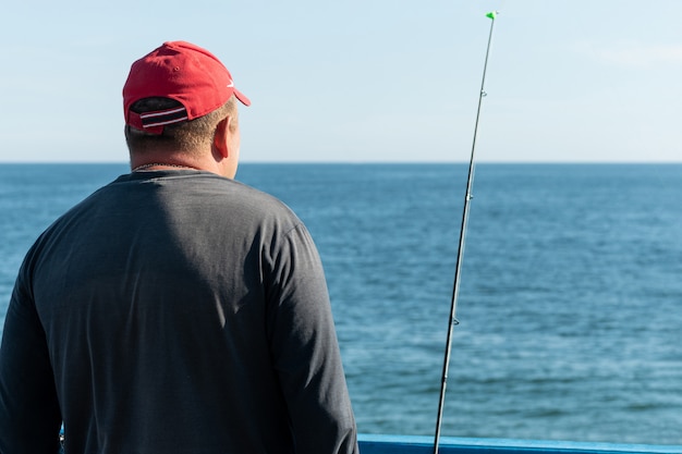 Pescatore pesca dal molo