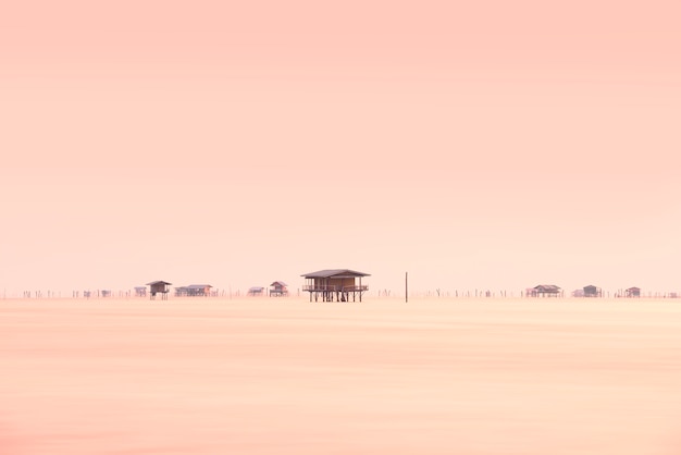 Fisherman and floating village in the ocean at sunrise