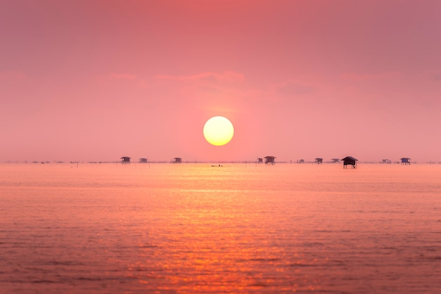 漁師と日の出で海に浮かぶ村