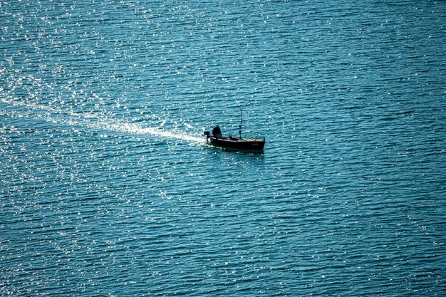 Photo fisherman in his motorboat on krka river croatia near the town of skradin during beautiful sunset