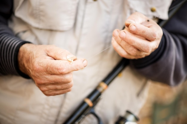 Fisherman hooks a worm on a fishing hook.