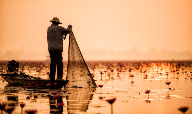 Foto pescatore del lago in azione durante la pesca, thailandia