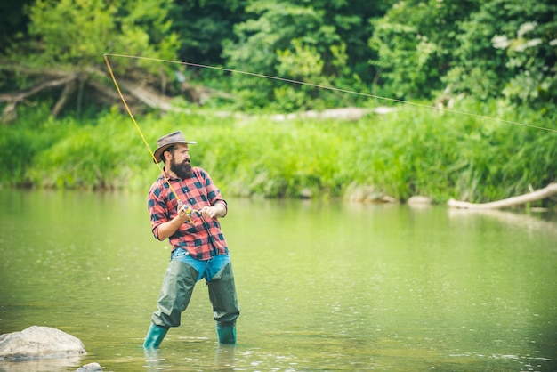 Fisherman man on river or lake with fishing rod