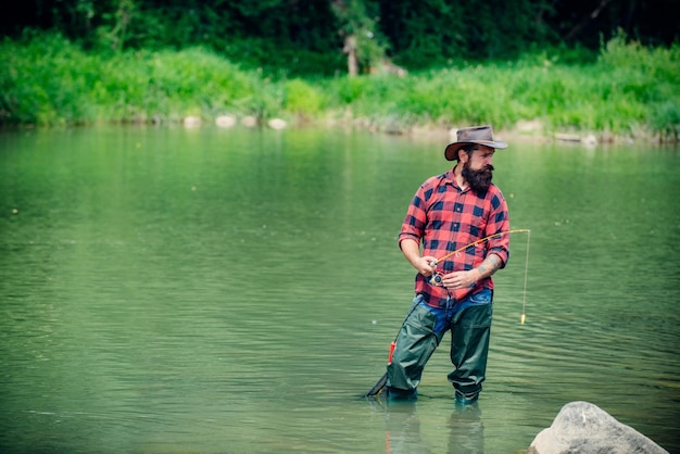Fisherman man on river or lake with fishing rod