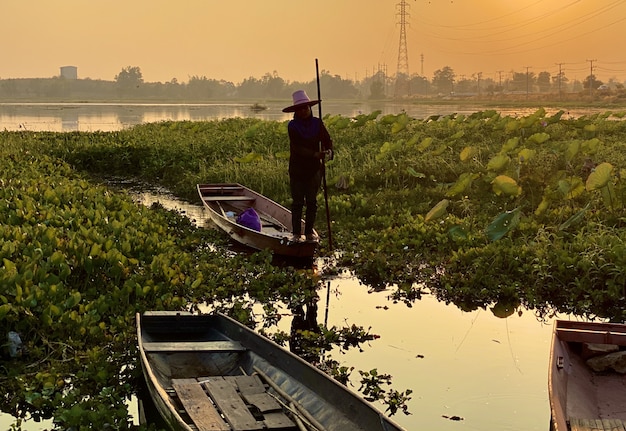 Photo fisherman oar wooden boat in sunset