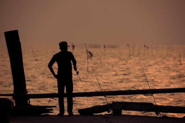 The fisherman silhouette with sunset sky