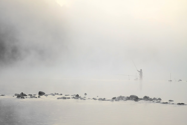 写真 水の中に立っている漁師