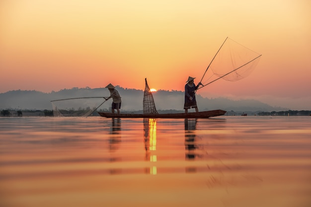 Pescatore sul fondo di alba alla campagna della tailandia