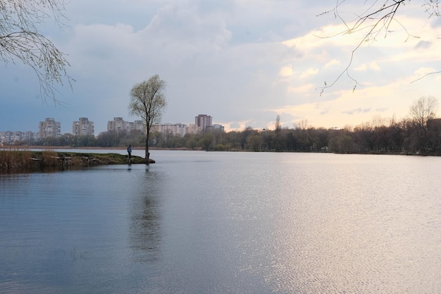 Fisherman in sunset on the city lake cheha in sumy ukraine beautiful reflect from sky and clouds