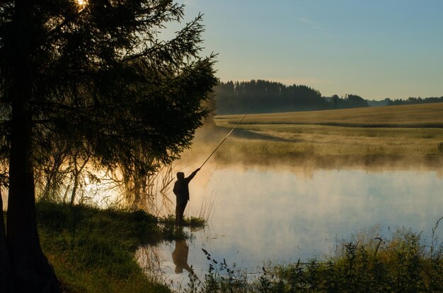 Photo a fisherman throws the bait on the lake