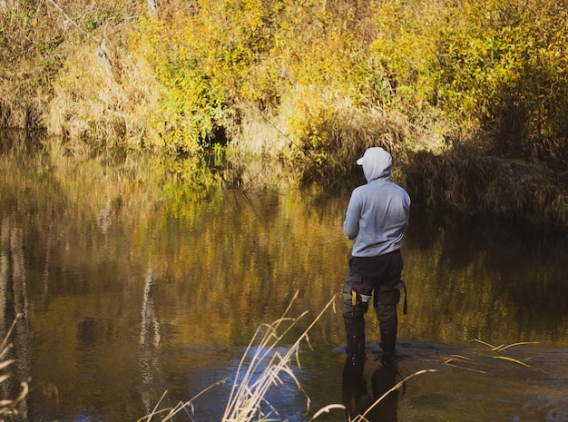 A fisherman throws a spinning rod a man catches fish in the river