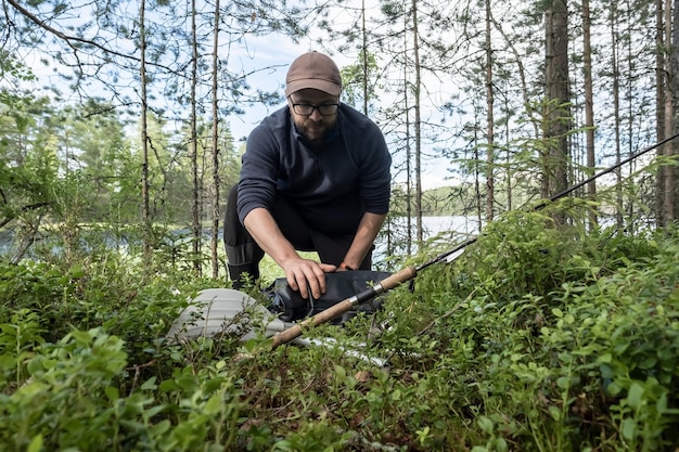 Fisherman unfolds a rubber boat a spinning rod and oars lie nearby