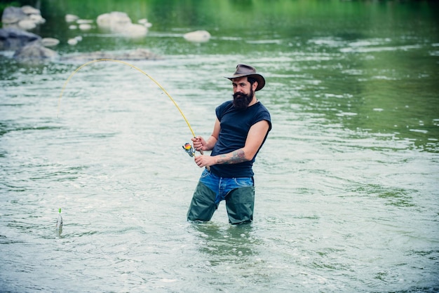 山川でロッドフライフィッシングを利用する漁師森の川で野生のマスを釣るフライフィッシング