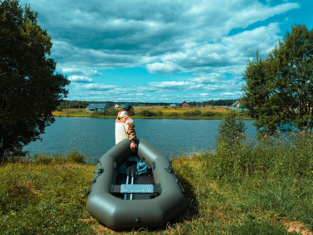 A fisherman with a boat goes down to the river