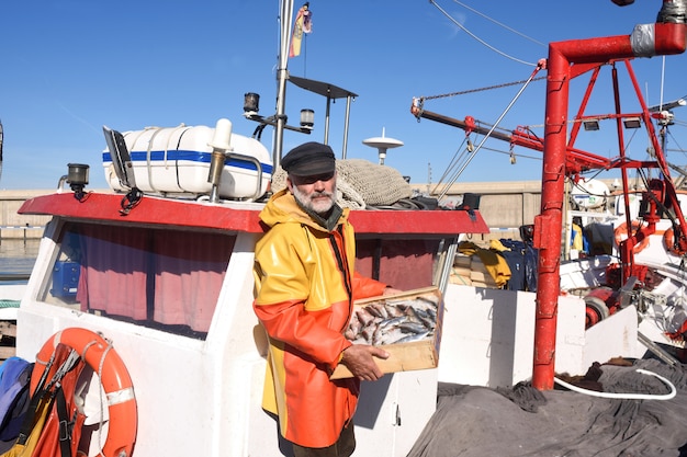 Рыбак с ящиком для рыбы внутри рыбацкой лодки